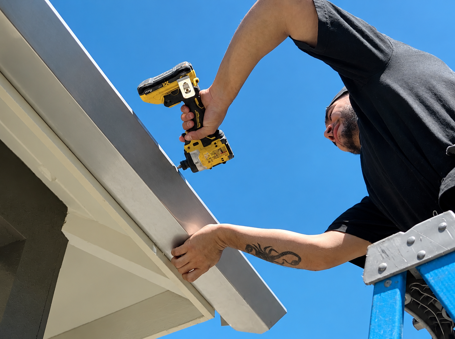Gutters Done Right installer on a ladder installing a gutter with a drill