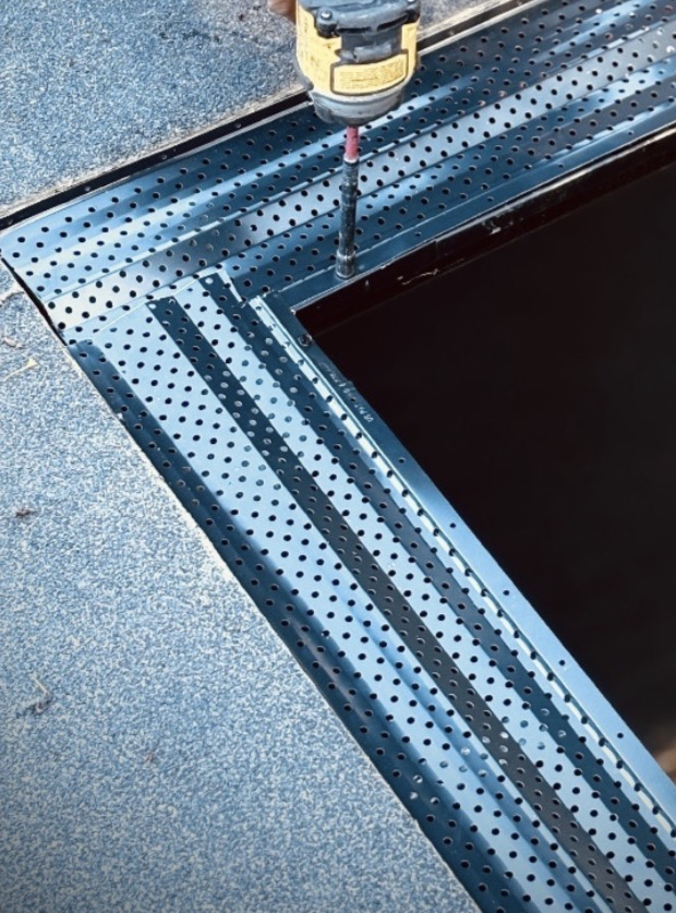 Perforated metal Built Solid leaf guard being screwed down over a gutter